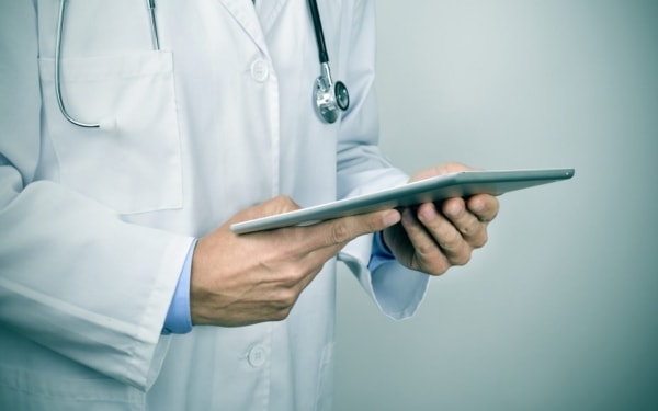 closeup of a young caucasian doctor man using a tablet computer